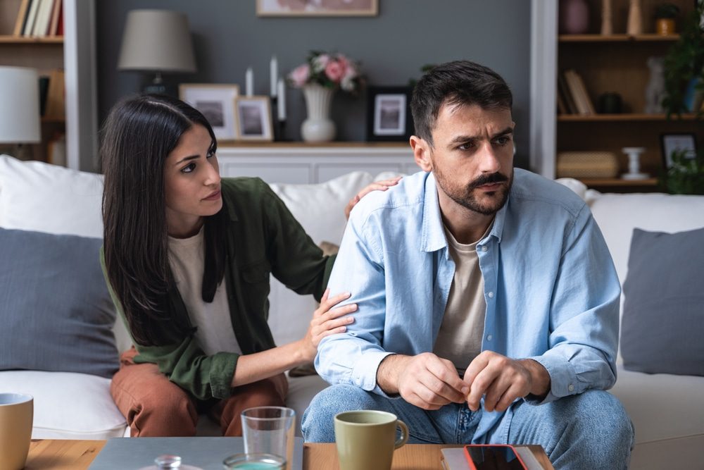 Relationship Counselling. Young married couple husband and wife sitting at home having problems in their marriage and a cold relationship. A boyfriend and a girlfriend roommates have an argument about spending too much money.