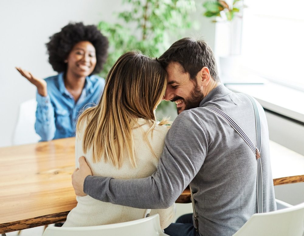Trusted Relationship Counselling in St. Thomas. Young happy couple and an agent in a new property, or professional psychologist advising spouses helping them restore marriage.