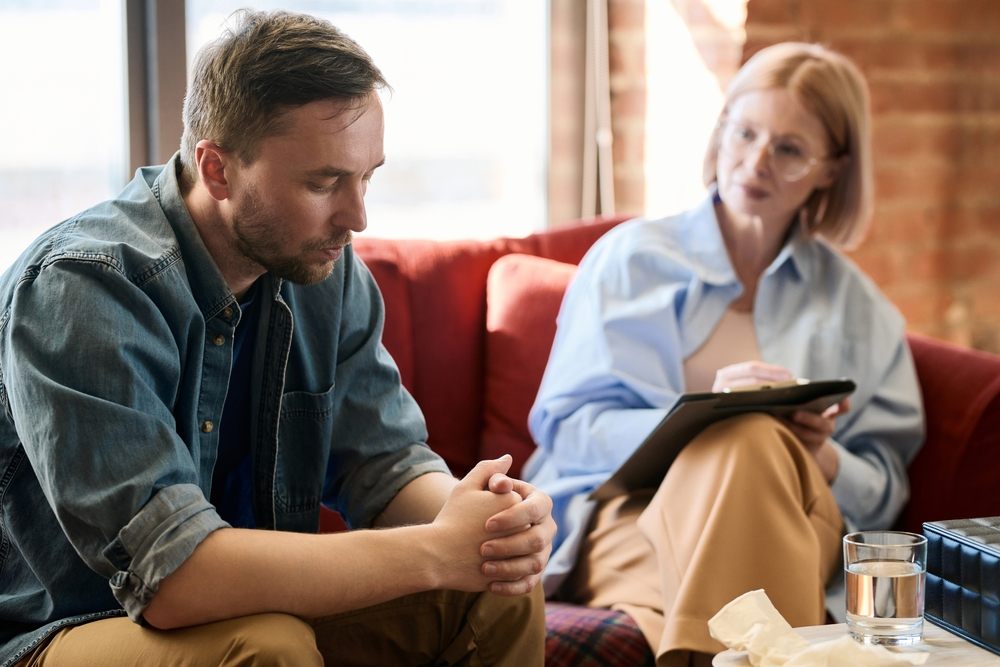 What Is Holistic Counselling? cognitive-behavioural therapy. Depressed man talking to psychologist.